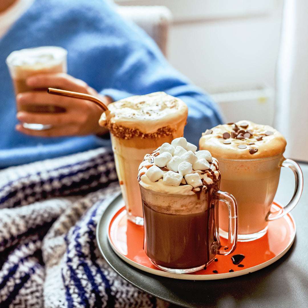 Duralex Lys Clear Stackable Glass Mug Set of 6 displayed with drinks topped with marshmallows and chocolate garnishes on a cozy table setting.