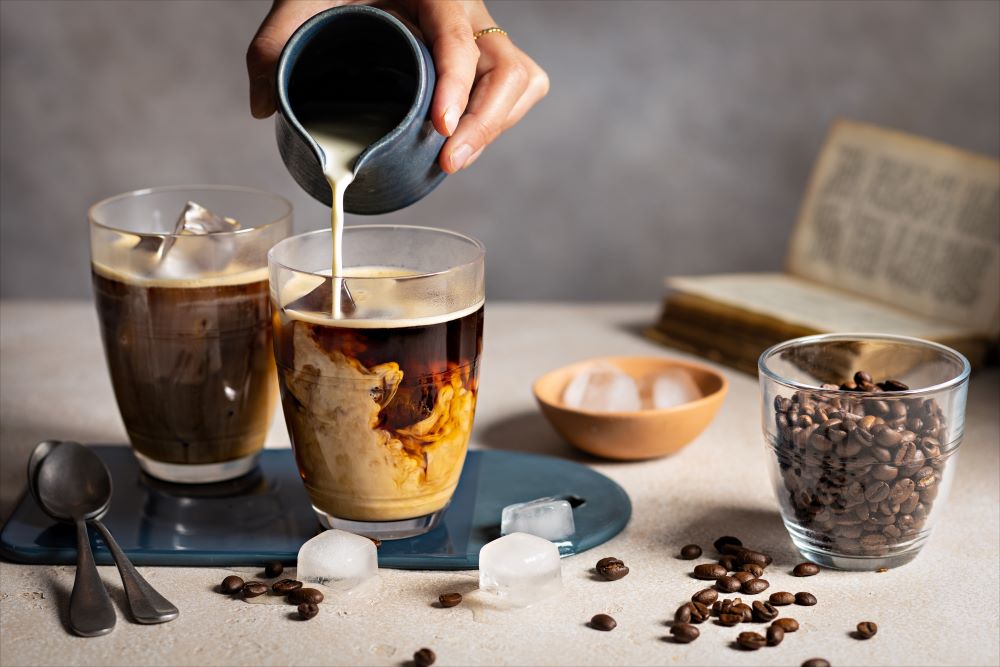 Le Gigogne® Glass Tumblers by Duralex, styled with coffee and milk being poured, highlighting their versatility for beverages like coffee and desserts.