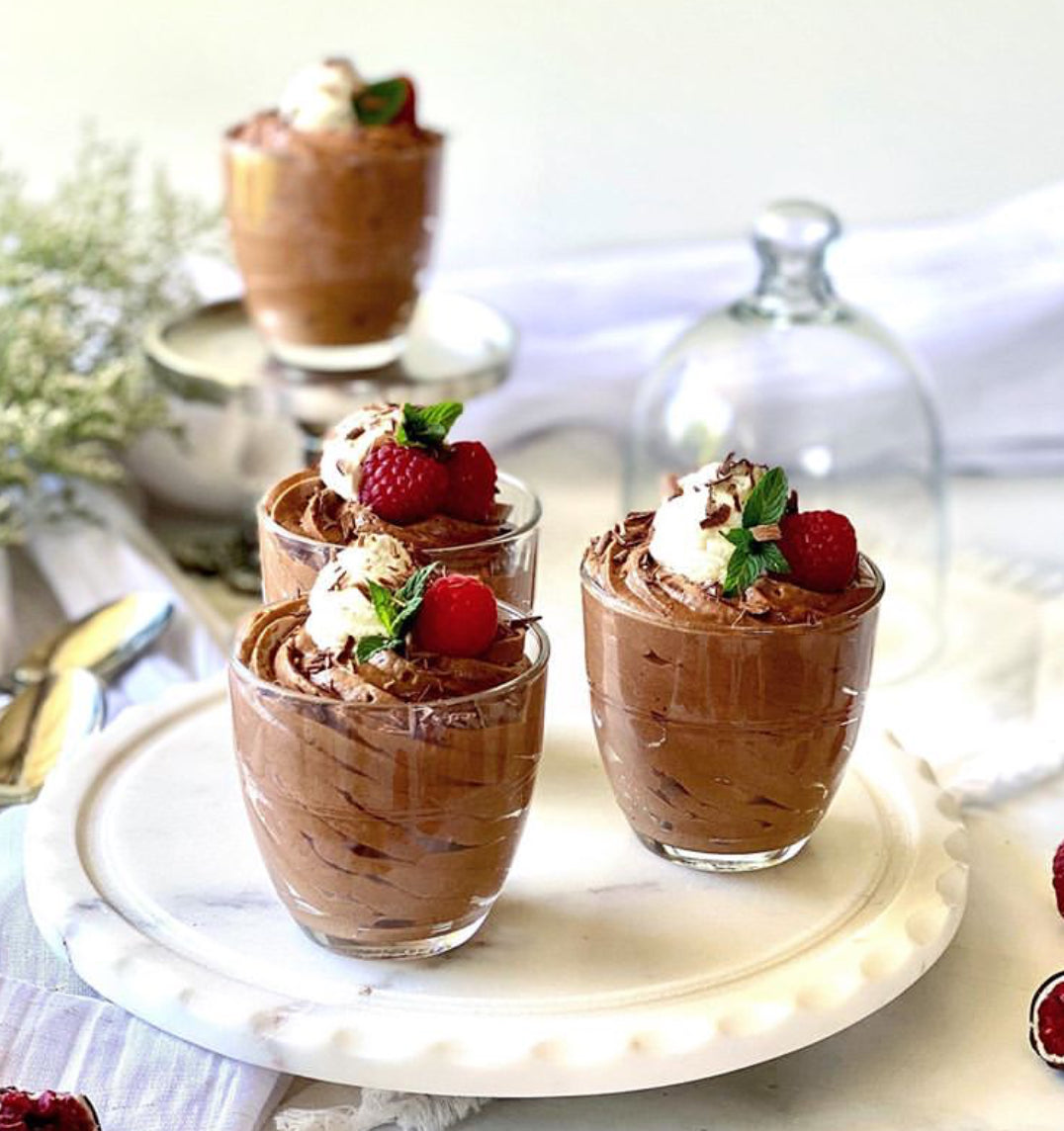 Four Le Gigogne® Glass Tumblers from Duralex filled with chocolate mousse and topped with raspberries and cream on a decorative plate.