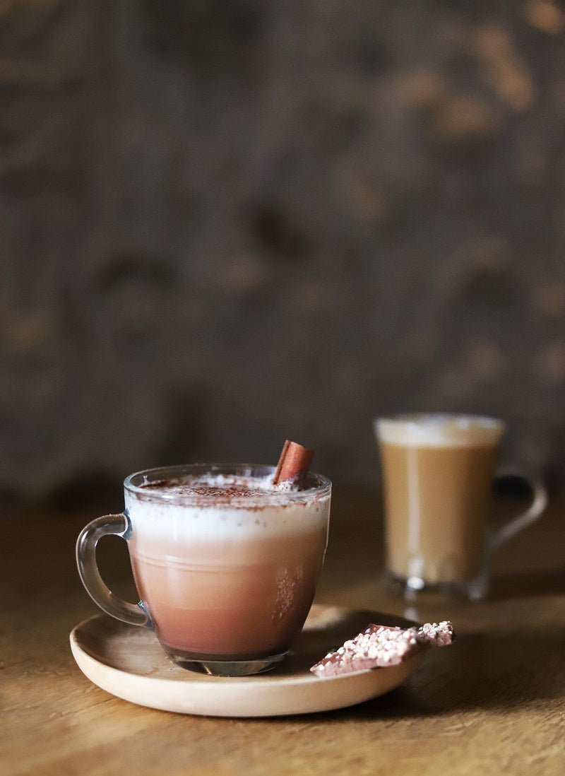Le Gigogne® Glass Mug from Duralex featuring a warm beverage with cinnamon, served with a snack on a wooden plate.